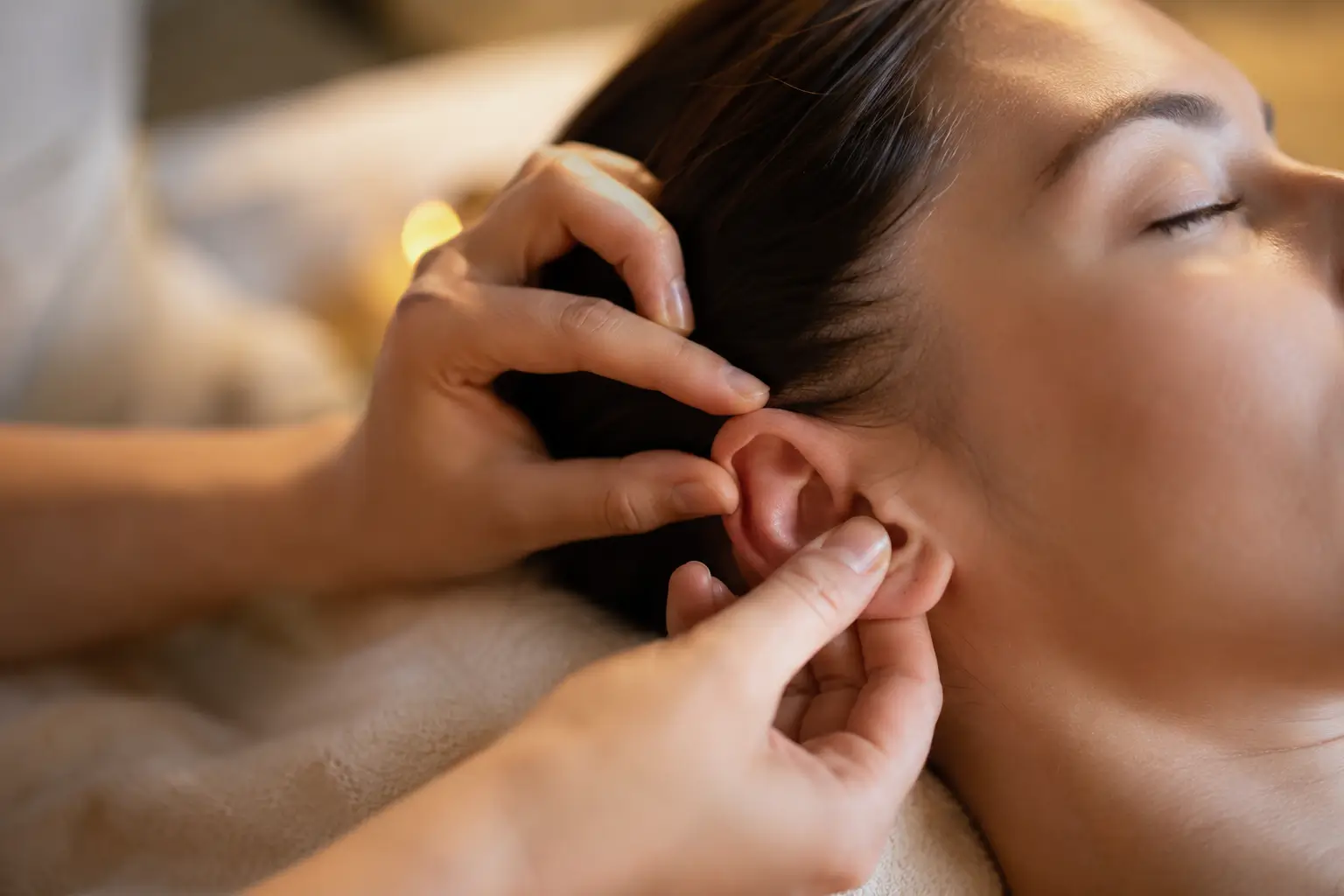 Stimulation du pavillon de l’oreille pendant une séance de réflexologie auriculaire